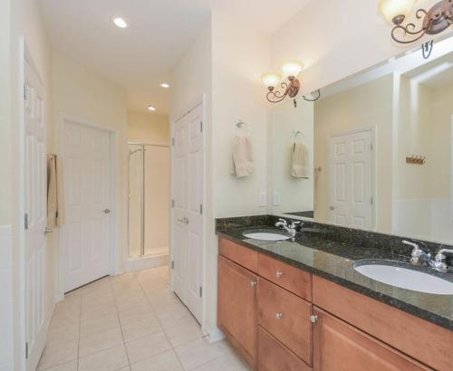 Un baño con dos lavabos y una ducha. en Comfortable Home on Golf Course in NSB - 1929T, en New Smyrna Beach