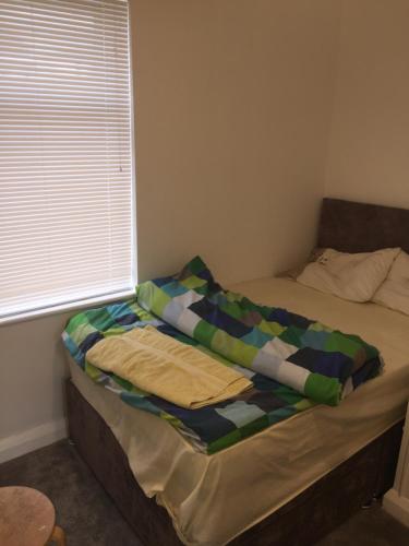 a bed with a blanket on it in a bedroom at Worcester Town Home & Garden in Hindlip
