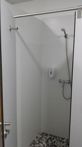 a shower with a glass door in a bathroom at Albergue & Rooms Murgadán in Padrón