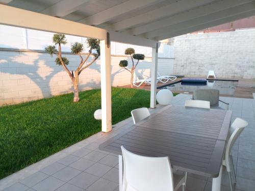eine Terrasse mit einem Tisch und Stühlen sowie einem Hof in der Unterkunft Villa Uluvud by Xenia Sicily Villas in Alcamo