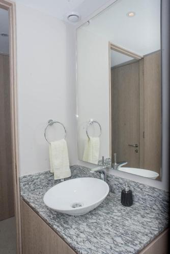 a bathroom with a white sink and a mirror at PENINISULA ViSTA AL MAR BY ENNA INN IXTAPA in Ixtapa