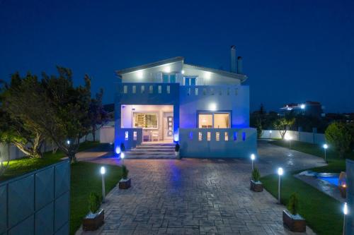 a blue house with lights on it at night at Muthee Luxurious Private Villa in Laganas