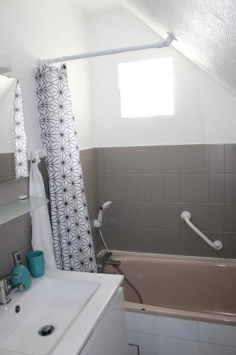 a bathroom with a sink and a bath tub at Au cœur du centre historique in Bayeux