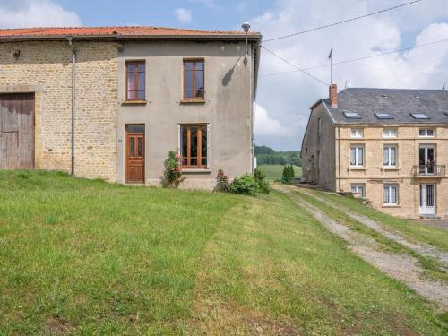 an old house and a barn on a grass field at Vintage holiday home with private garden in Nouart