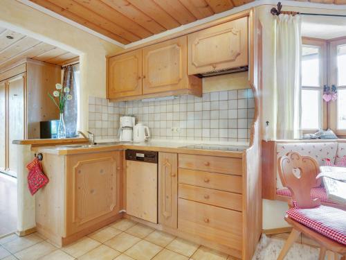 a small kitchen with wooden cabinets and a sink at Apartment in Ruhpolding with Alps view in Ruhpolding