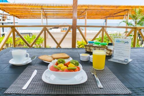a table with a bowl of fruit and bread and juice at Villa Kite in Santa Marianita