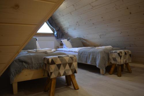 2 łóżka w pokoju z drewnianymi ścianami w obiekcie Osada Witów - apartament „Siwa Kopa” w mieście Witów