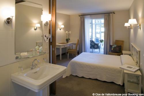 a hotel room with a bed and a sink at Clos de Vallombreuse, The Originals Relais in Douarnenez