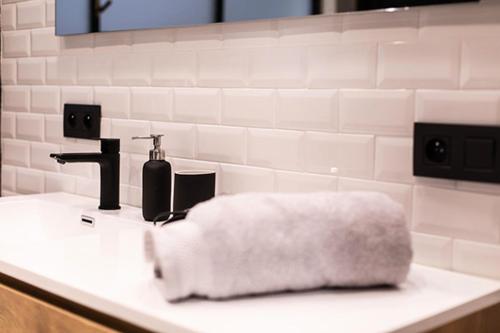 a white towel sitting on a bathroom sink at GITADIN - Deluxe Suite Rousseau - Historical center in Liège