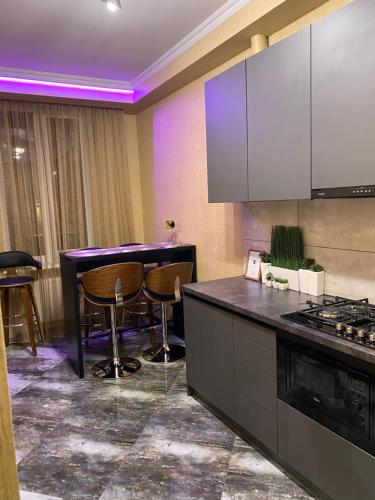 eine Küche mit einer Theke und eine Bar mit Hockern in der Unterkunft Apartments Lux in city center Lviv in Lwiw