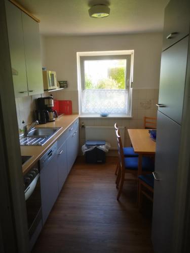 a small kitchen with a table and a window at Ferienwohnungen und Ferienhaus im Nixenweg in Hohwacht
