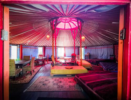Zimmer mit einer lila Decke mit Sofas und Tischen in der Unterkunft Au Bonheur Nomade in Livry