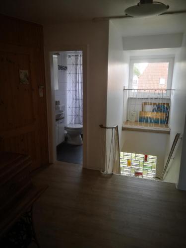 a bathroom with a toilet and a window at Ferienwohnungen und Ferienhaus im Nixenweg in Hohwacht