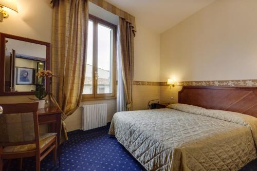 um quarto de hotel com uma cama e uma janela em Hotel Arizona em Florença