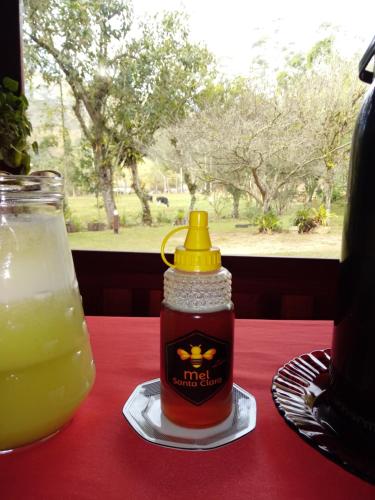 a bottle of ketchup on a table with a drink at Pousada Sítio das Astrapéias in Visconde De Maua