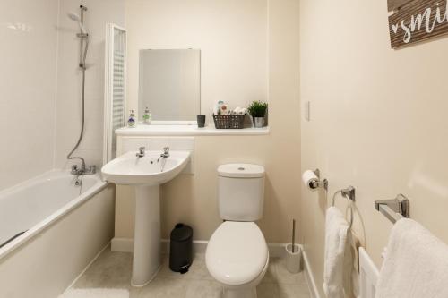 ein weißes Bad mit einem WC und einem Waschbecken in der Unterkunft City Centre Apartment - Free Parking, Fast Wifi, Smart TV with Netflix and Xbox by Yoko Property in Milton Keynes