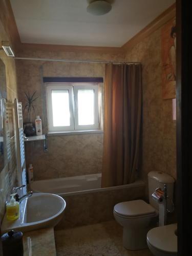 a bathroom with a sink and a toilet and a tub at Villa Porto de Mós near Fatima in Porto de Mós