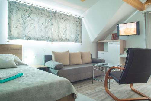 a living room with a bed and a couch at Studio Apartment Karlo in Drežnik Grad