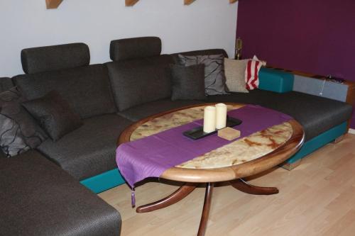 a living room with a couch and a table with candles at Maisonette Deluxe by fewo-amperland in Olching