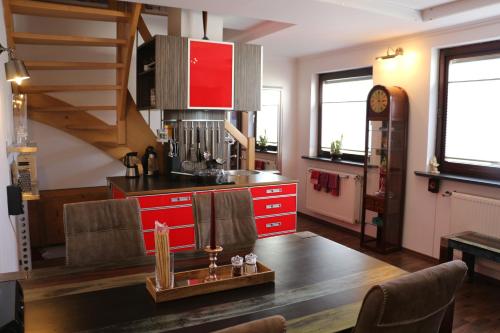 a kitchen with red cabinets and a table in a room at Maisonette Deluxe by fewo-amperland in Olching