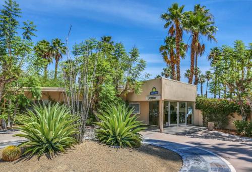 um edifício com palmeiras em frente em Days Inn by Wyndham Palm Springs em Palm Springs