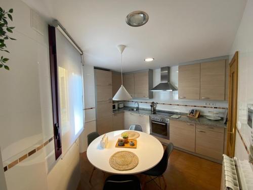 a kitchen with a white table and chairs in it at Apartamento LLAR DEL CARES in Arenas de Cabrales