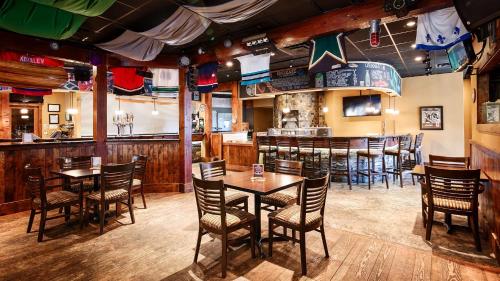 a restaurant with tables and chairs and a bar at Best Western The Westerly Hotel in Courtenay