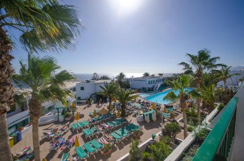 een luchtzicht op een resort met een zwembad en palmbomen bij Apartamentos La Peñita in Puerto del Carmen