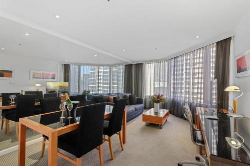 a living room with a couch and a table at The Sebel Quay West Suites Sydney in Sydney