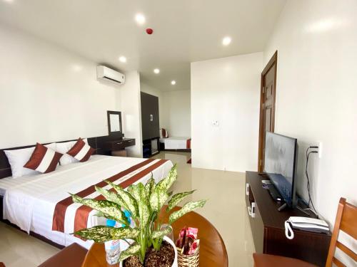 a bedroom with a bed and a desk and a television at Thăng Long Hotel in Con Dao