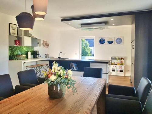 a dining room table with a vase of flowers on it at Apartments bei Playmobil 1,130m2,24h Self Check-in, free Parking in Zirndorf