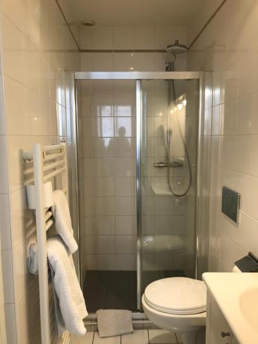 a bathroom with a shower and a toilet and towels at Lyo Hôtel - Centre Lyon Perrache in Lyon