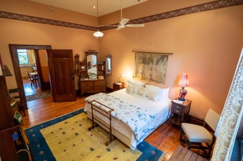 Buxton Manor في أديلايد: غرفة نوم بسرير وطاولة مع مصباح