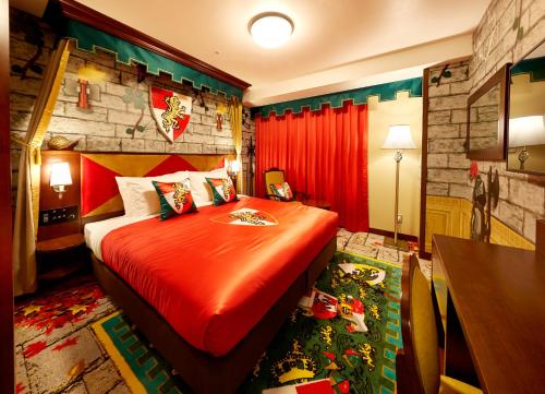a bedroom with a bed with a red comforter at LEGOLAND Japan Hotel in Nagoya