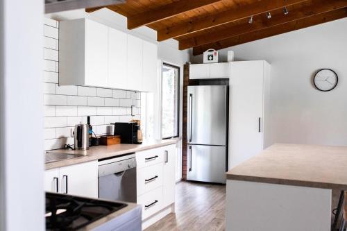 a kitchen with white cabinets and a stainless steel refrigerator at McCarthy Grove Maleny in Maleny