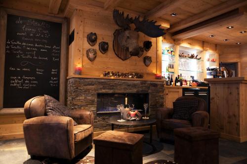 a room with a fireplace and two chairs and a table at Chalet-Hôtel Les Cimes in Le Grand-Bornand