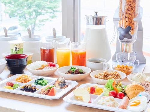 a table topped with plates of food and drinks at KOKO HOTEL Hidatakayama - formaly Hotel Wing Hida Takayama in Takayama