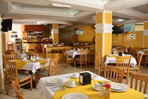 a restaurant with tables and chairs with yellow tablecloths at Hotel Paradise Inn in Chilpancingo de los Bravos