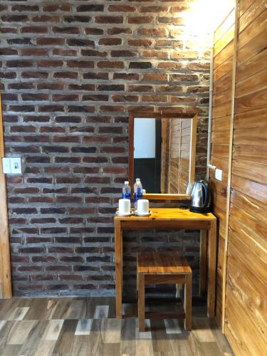 a bathroom with a wooden table and a mirror at Mai Chau Green Ecohouse in Hòa Bình