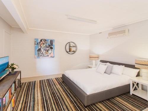 a bedroom with a bed and a flat screen tv at Easy Living at 14 Daphne Street in Forster