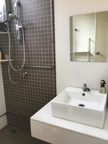 a bathroom with a sink and a shower with a mirror at BM Rooms in Bukit Mertajam