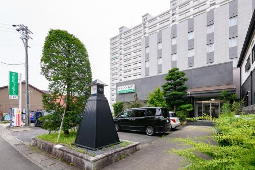 una torre del reloj negro en medio de una calle en Inuyama Miyako Hotel, en Inuyama
