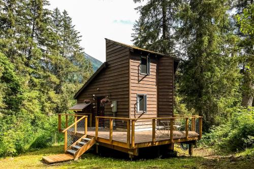 a cabin in the woods with a large deck at Girdwood Mountain House in Girdwood