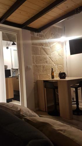 1 dormitorio con mesa y pared de piedra en La casa a due passi dal mare en Marettimo