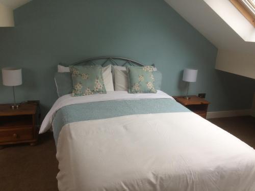 een slaapkamer met een groot wit bed en 2 nachtkastjes bij The Annexe - Acomb Green in York