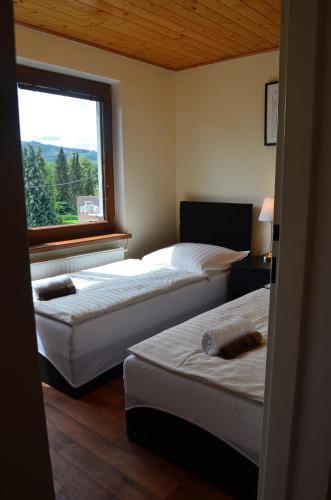 two beds in a room with a window at Apartment pod Lysou in Frýdlant nad Ostravicí