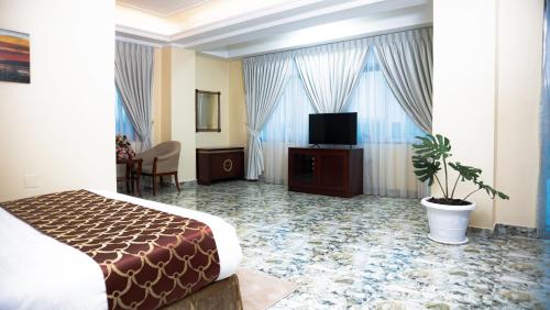 a hotel room with a bed and a flat screen tv at Dabi Hotel & Apartments in Addis Ababa