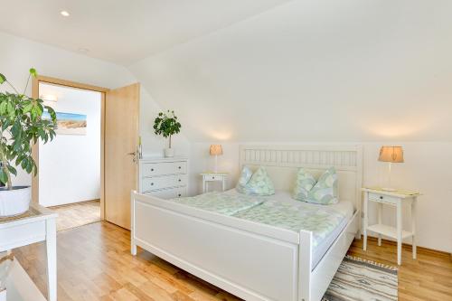 um quarto com uma cama branca e duas mesas em Ferienhäuser Fuchsweg em Stralsund
