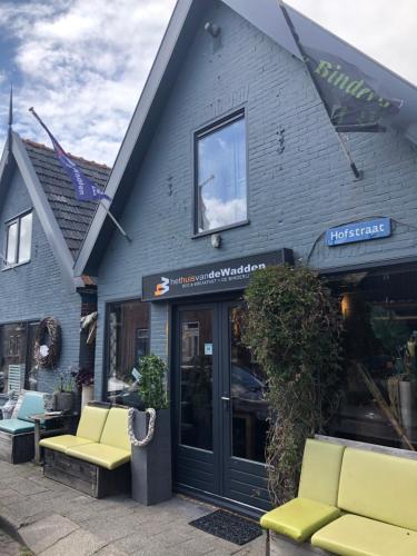 a store with yellow chairs in front of a building at Het Huis van de Wadden in Den Oever