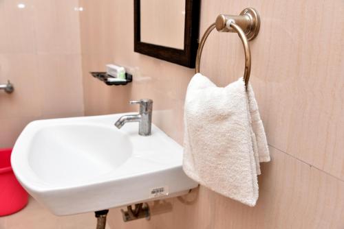 チェンナイにあるSree Devi Niwasの白いタオルがバスルームの洗面台に掛けられています